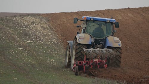 A Farmer Ploughing a Field with a Tractor 