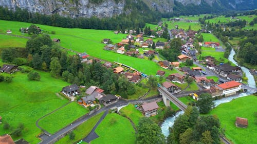 Drone Footage of a Train Passing by a Mountain Village 