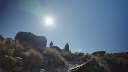 A Group of Photographers Walking in a Mountain Landscape on a Sunny Day