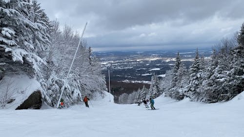 People Skiing Down a Snow Covered Hill