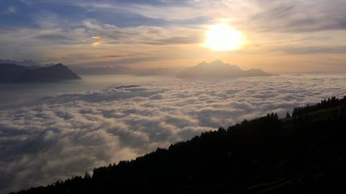 Drone Footage of Low Clouds in a Mountain Landscape at Sunset 