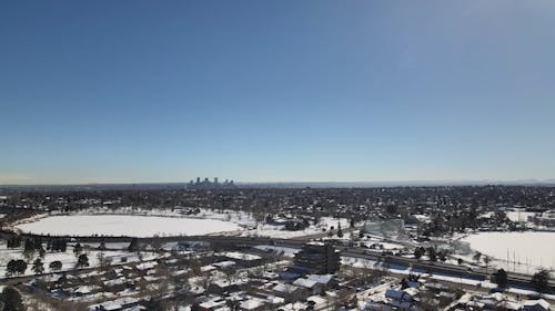 Drone View of a Snow Covered City under a Clear Blue Sky 