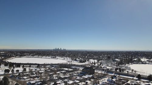 Drone View of a Snow Covered Town under a Clear Blue Sky