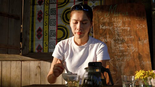 A Young Woman Enjoying a Cup of Ice Cream 