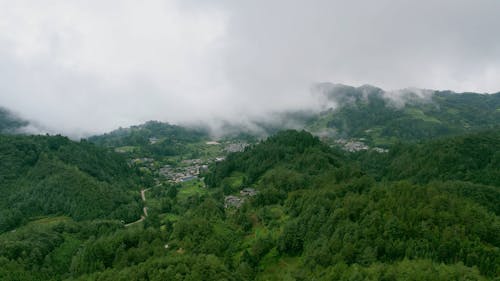 Aerial View of a Village Surrounded by Green Mountains 