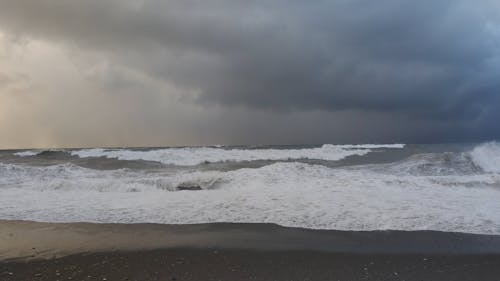 Breaking Waves on a Sandy Beach under a Stormy Sky
