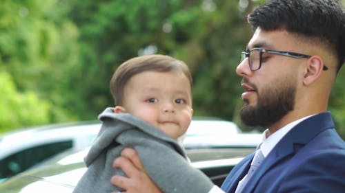 Close up of an Affectionate Father Holding and Kissing his Son 