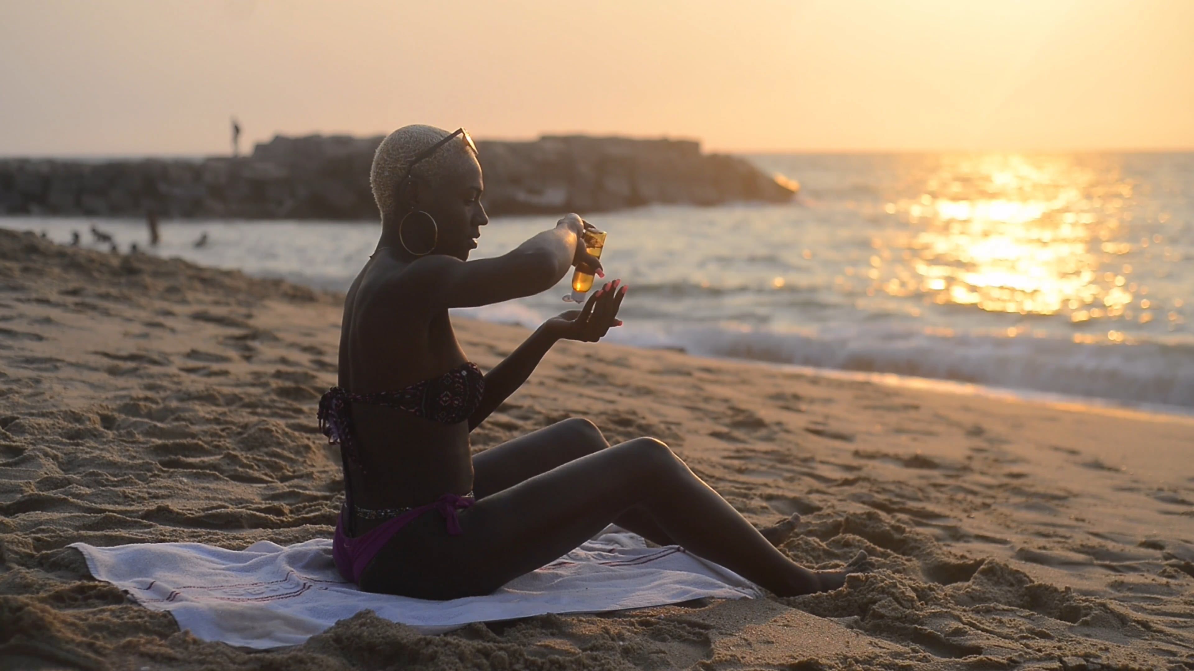 A woman sitting on the beach at sunset Free Stock Video Footage ...
