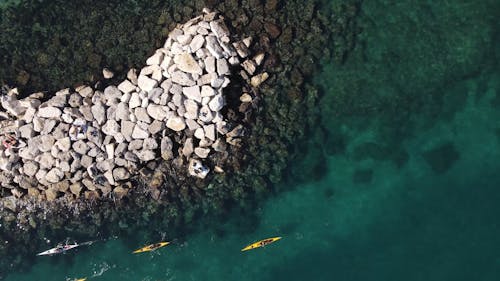 Top View of People Kayaking near a Breakwater 