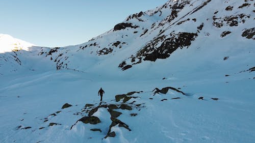 Drone Footage of a Hiker on a Snow Covered Mountain 