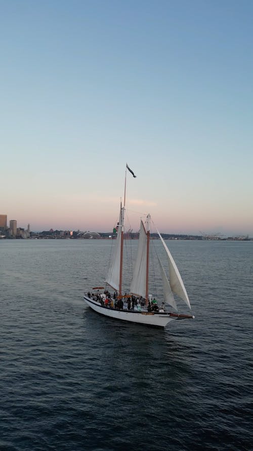 Drone Footage of a Boat Sailing near the Coast of Seattle at Sunset