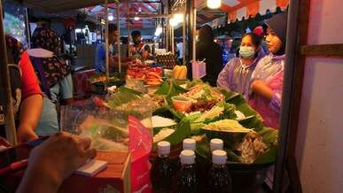 people are buying food at a market