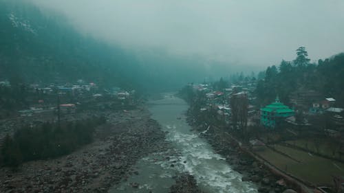Drone Footage of a River and Village Houses on a Rainy Day