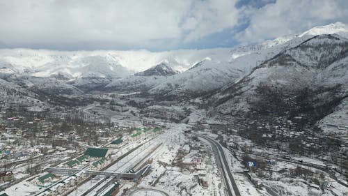 Aerial Footage of a Town Surrounded by Snow Covered Mountains