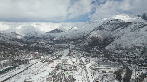 Drone Footage of a Town Surrounded by Snow Covered Mountains 