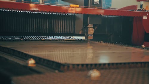 A Factory Worker Operating a Laser Cutting Machine 