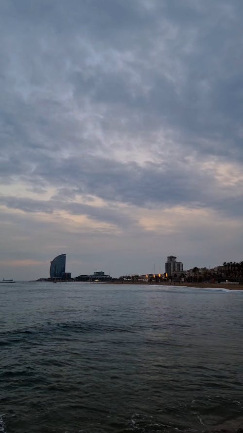 Time Lapse of Moving Clouds over a Coastal City at Dusk 