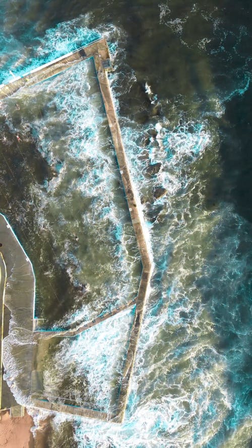 Top View of Sea Waves Breaking against a Rock Pool