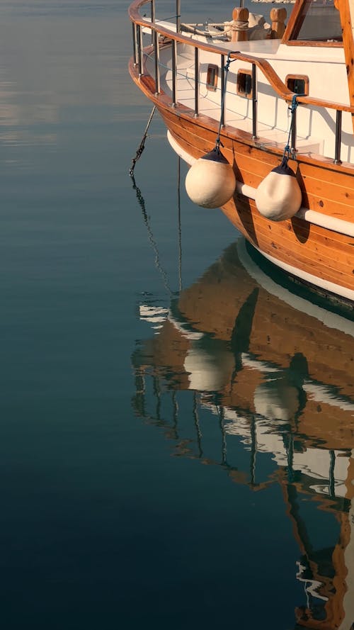 A Wooden Ship and its Reflection on the Water Surface 