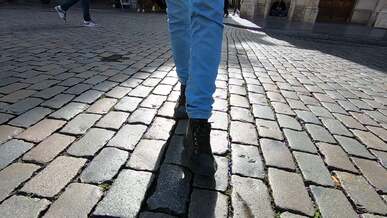 a person walking on a cobblestone street in slow motion