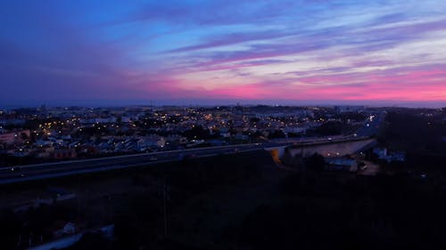 Beautiful violet sunset in Cascais, drone shot of highway, Portugal