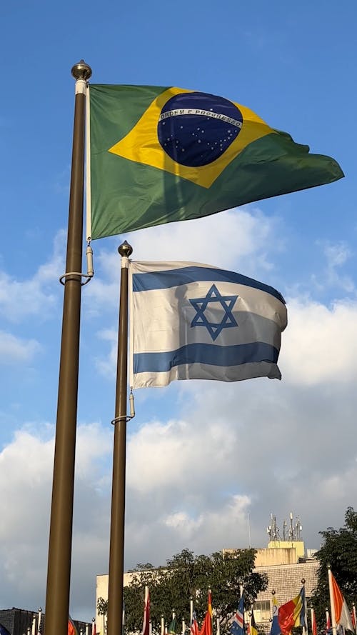 The National Flags of Brazil and Israel Waving on Poles 
