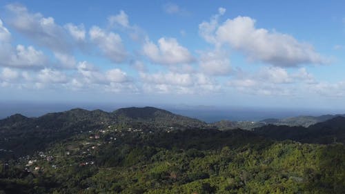 Green Mountains under a Blue Sky with White Clouds 