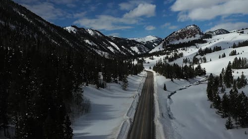 Drone Video of a Road in a Snow Covered Mountain Landscape 