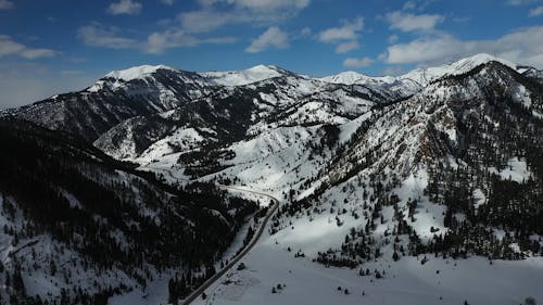 Aerial Footage of a Road in a Snowy Mountain Landscape 