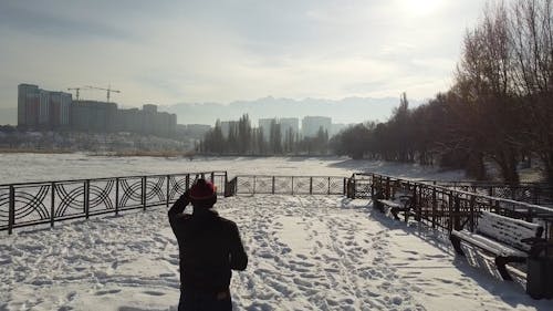 Drone Video of a Man in a Snow Covered Park in the City of Almaty, Kazakhstan