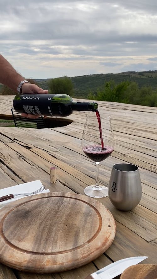 A Person Pouring Red Wine into a Glass