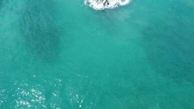 an aerial view of a rock in the ocean