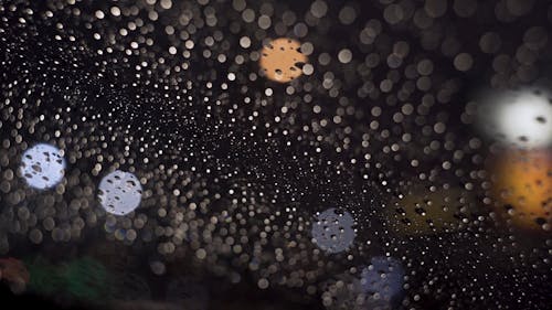 Raindrops on car windshield at night