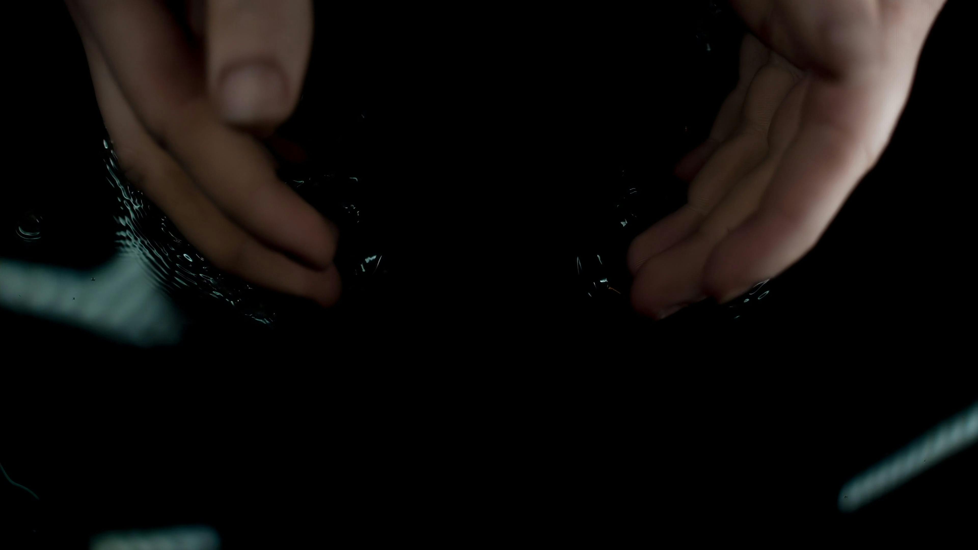 close up of a person submerging their hands in a dark liquid 16392050