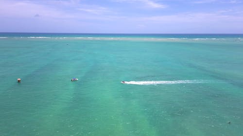 A Jet Ski and a Motorboat on Turquoise Sea Waters