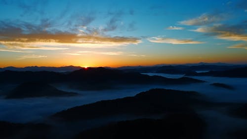 The Sun Rising over a Mountain Landscape