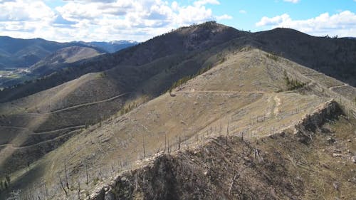 Panoramic View of a Mountain Landscape with Green Fields and a River 