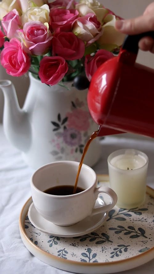 A Person Pouring Coffee into a White Cup