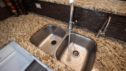 High Angle View of a Kitchen Sink with Running Water 