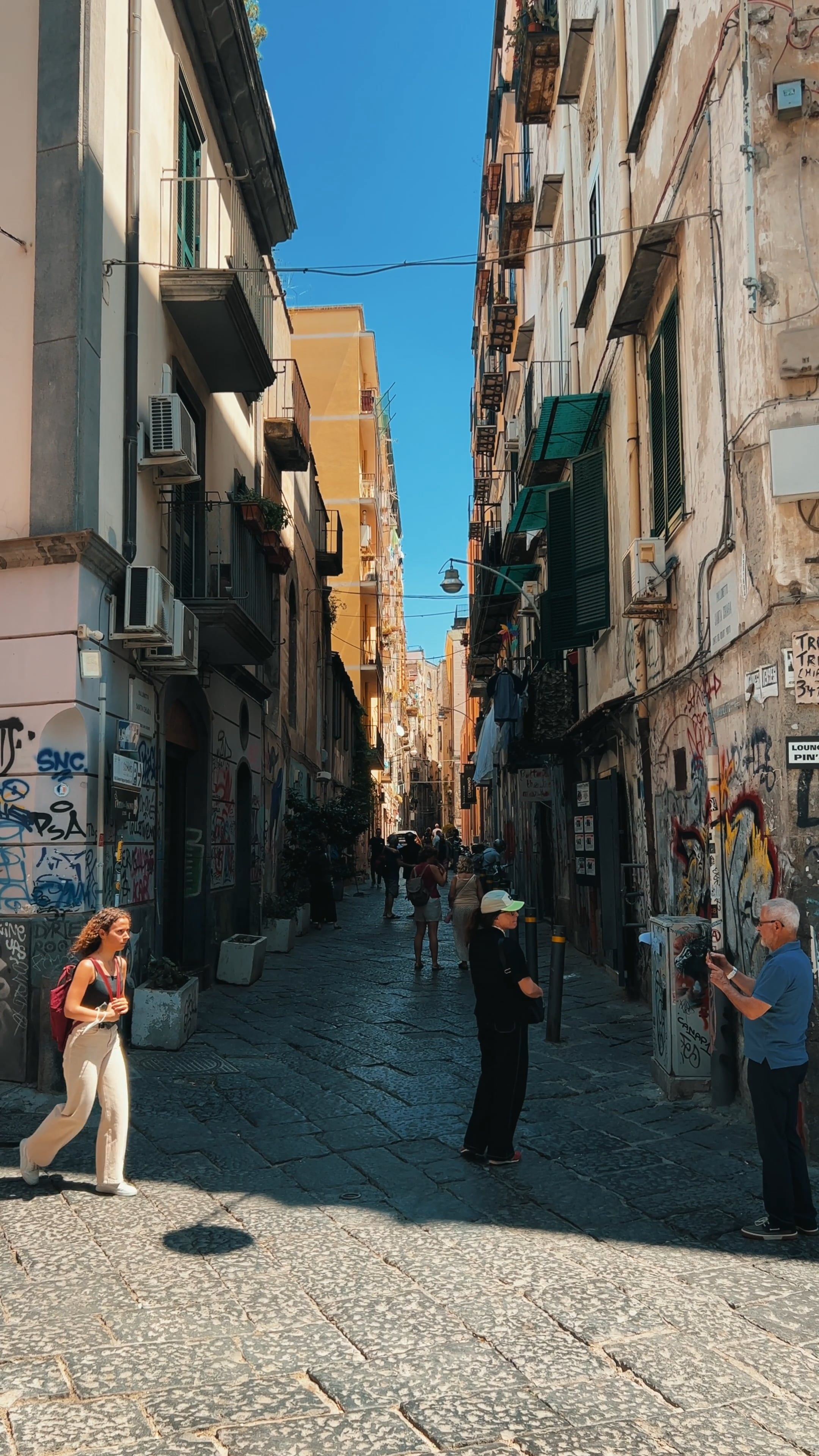 a narrow street with people walking down it 16668257 — free pexels stock footage