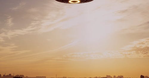 UFO on the background of a city sunset