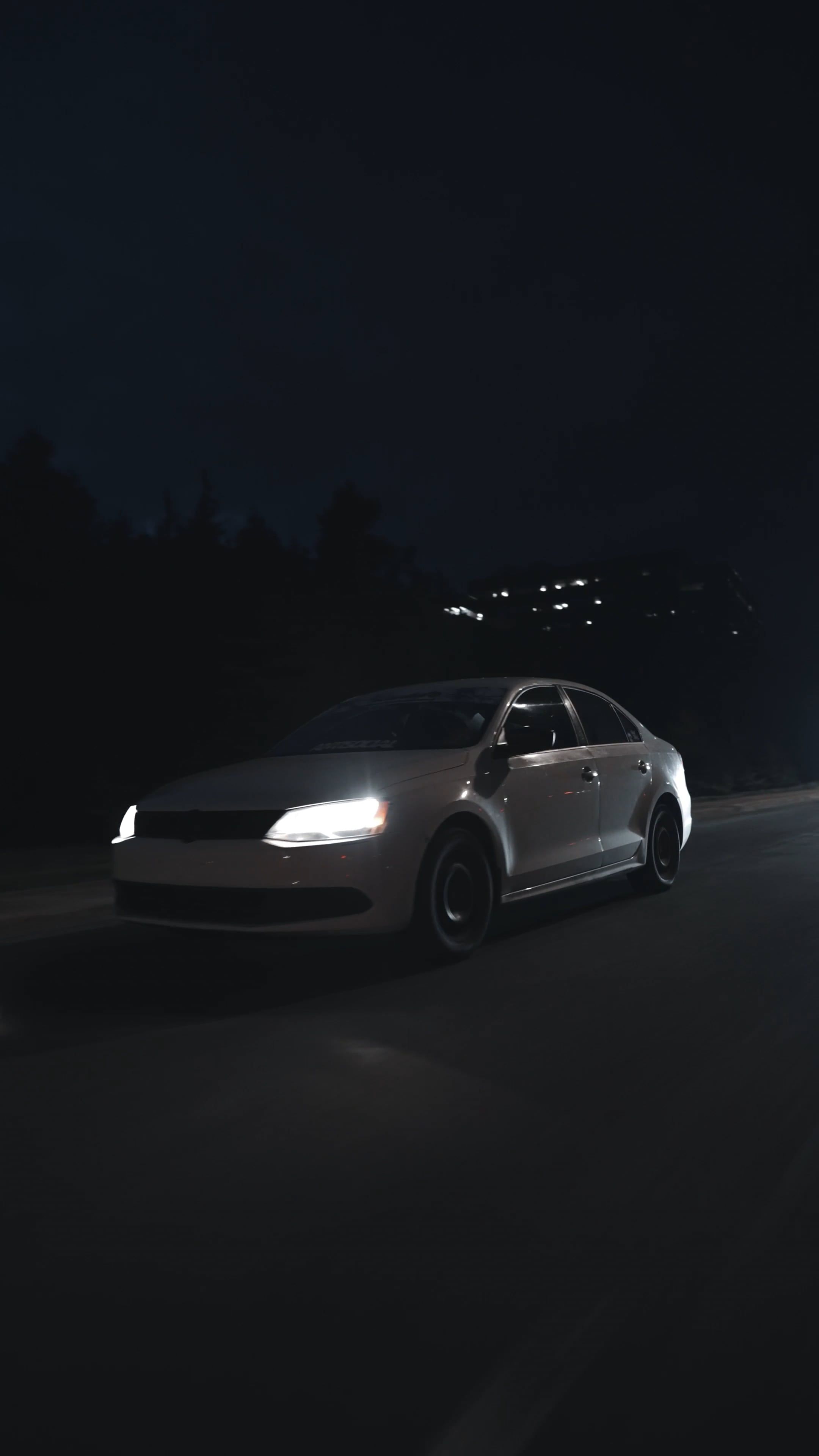 a car driving down a road at night 16762623