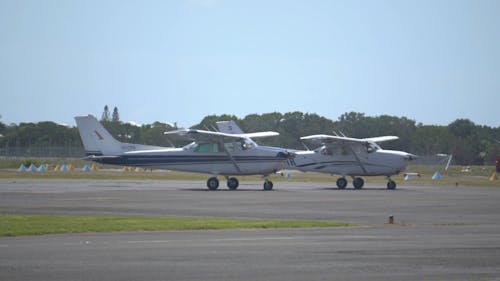 Two Private Airplanes Waiting On The Runway