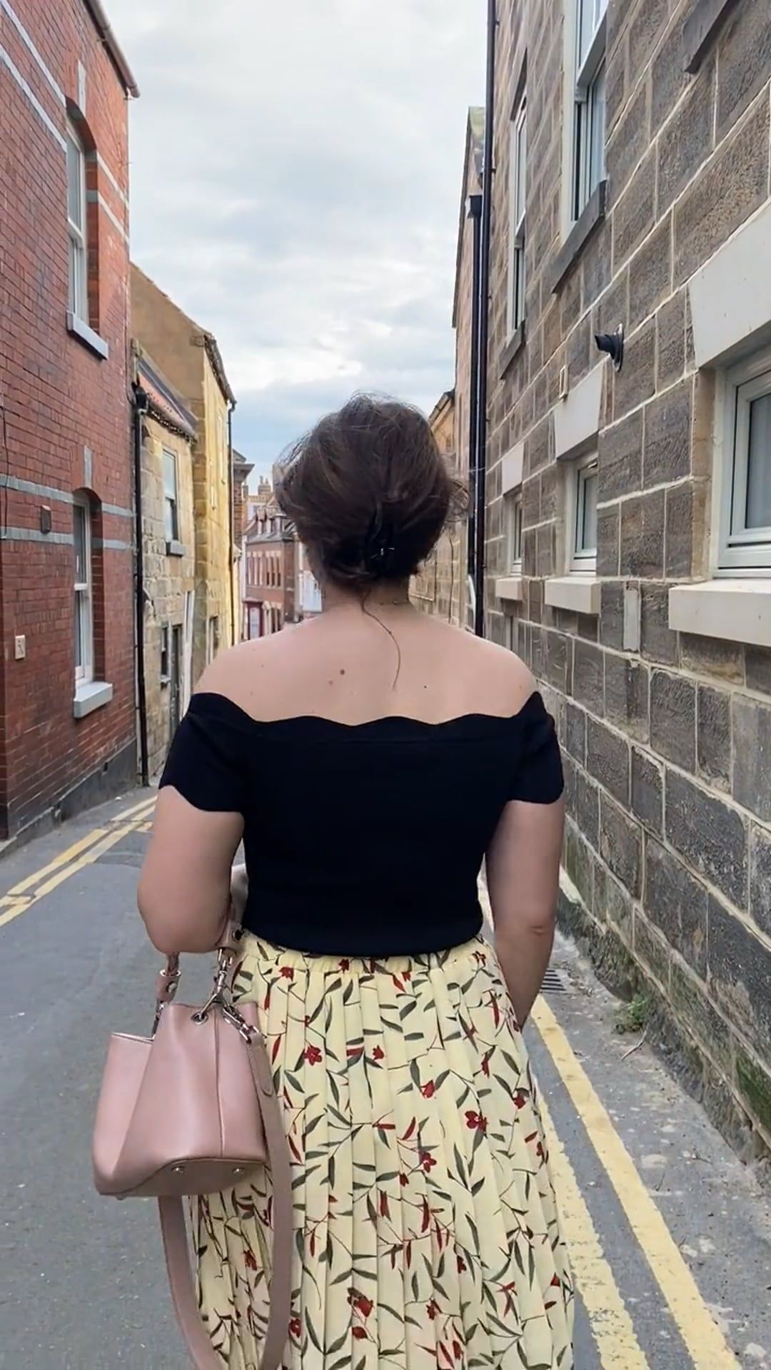 Back View of a Young Woman Walking Down a Narrow Street Free Stock ...