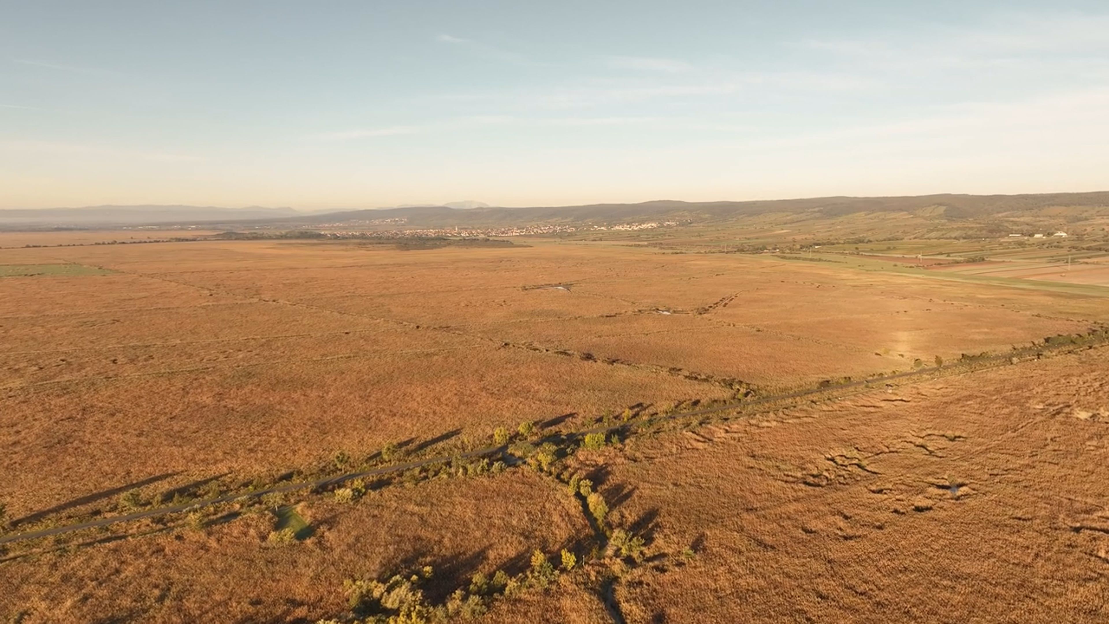 An aerial view of a field with a river running through it Free Stock ...