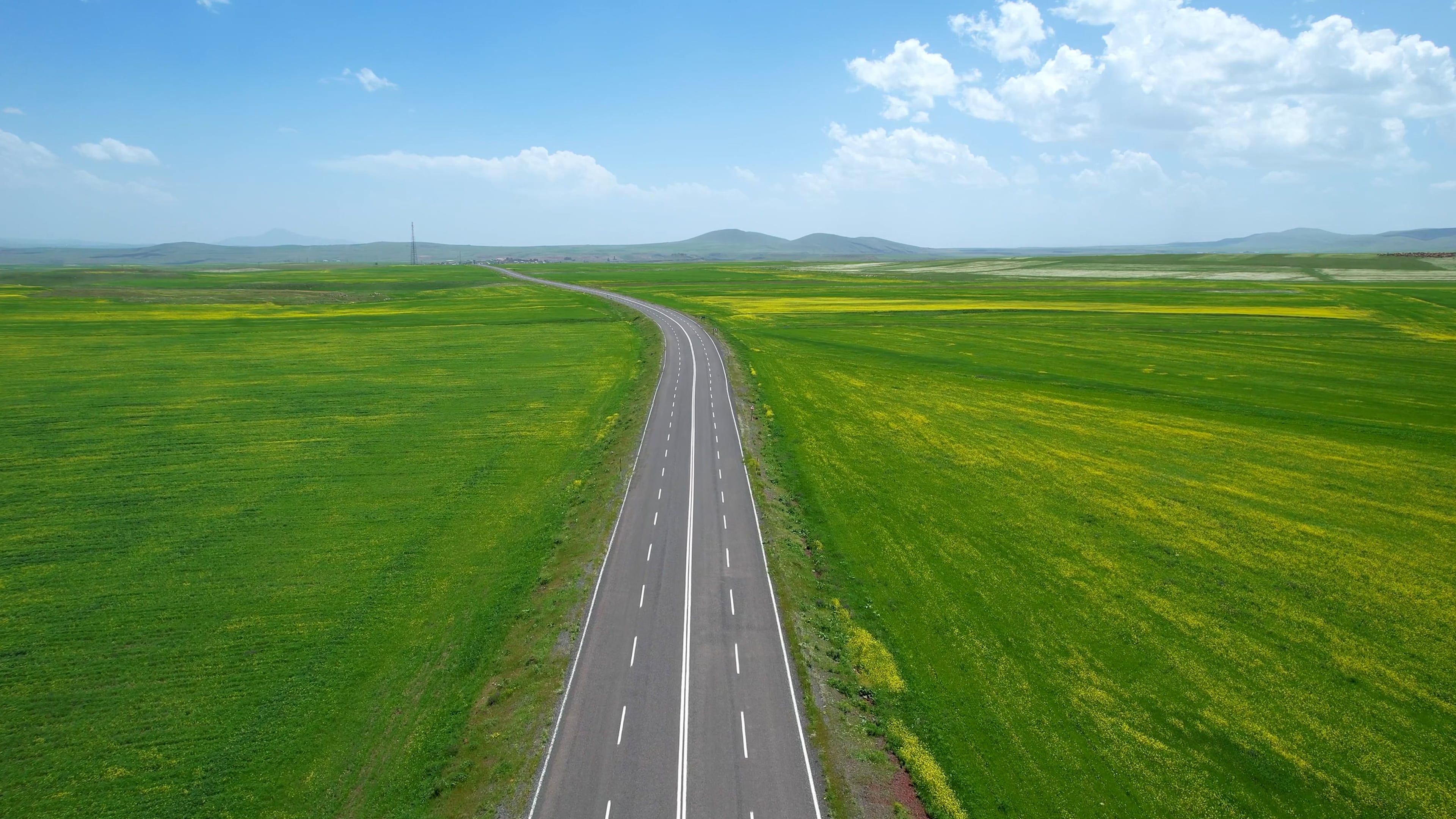 An empty road in the middle of a green field Free Stock Video Footage ...