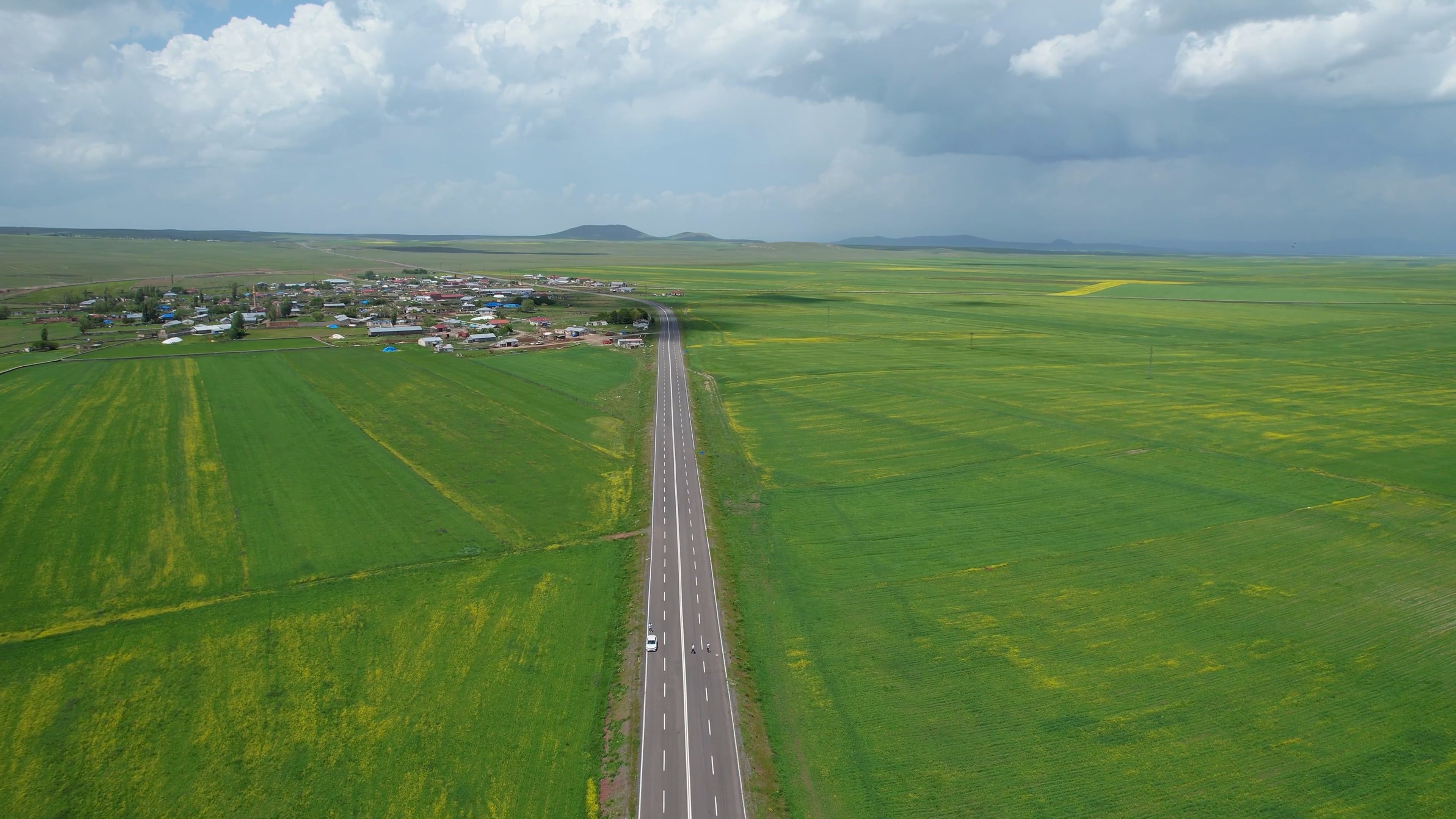 An aerial view of a road and green fields Free Stock Video Footage ...