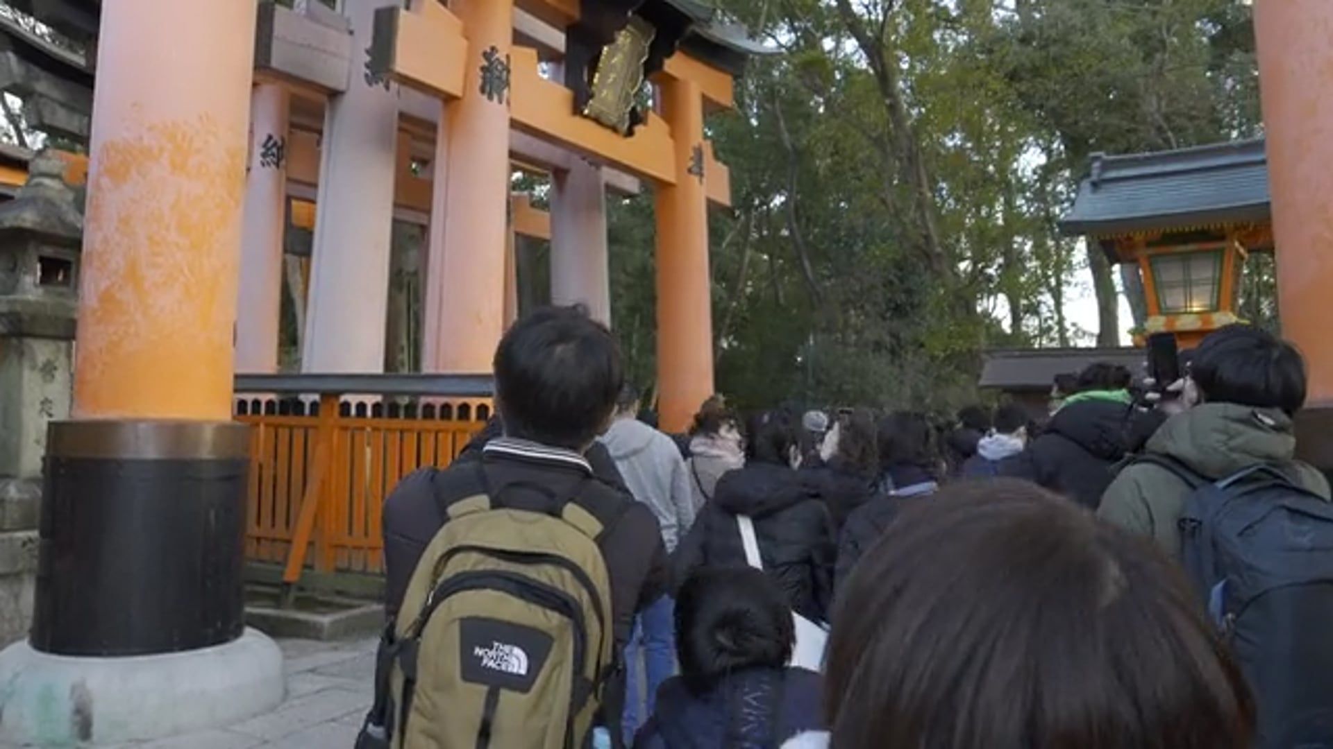 People walking through a tunnel of orange tori gates Free Stock Video ...
