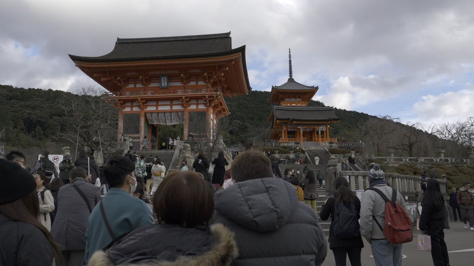 People walking through a tunnel of orange pillars Free Stock Video ...