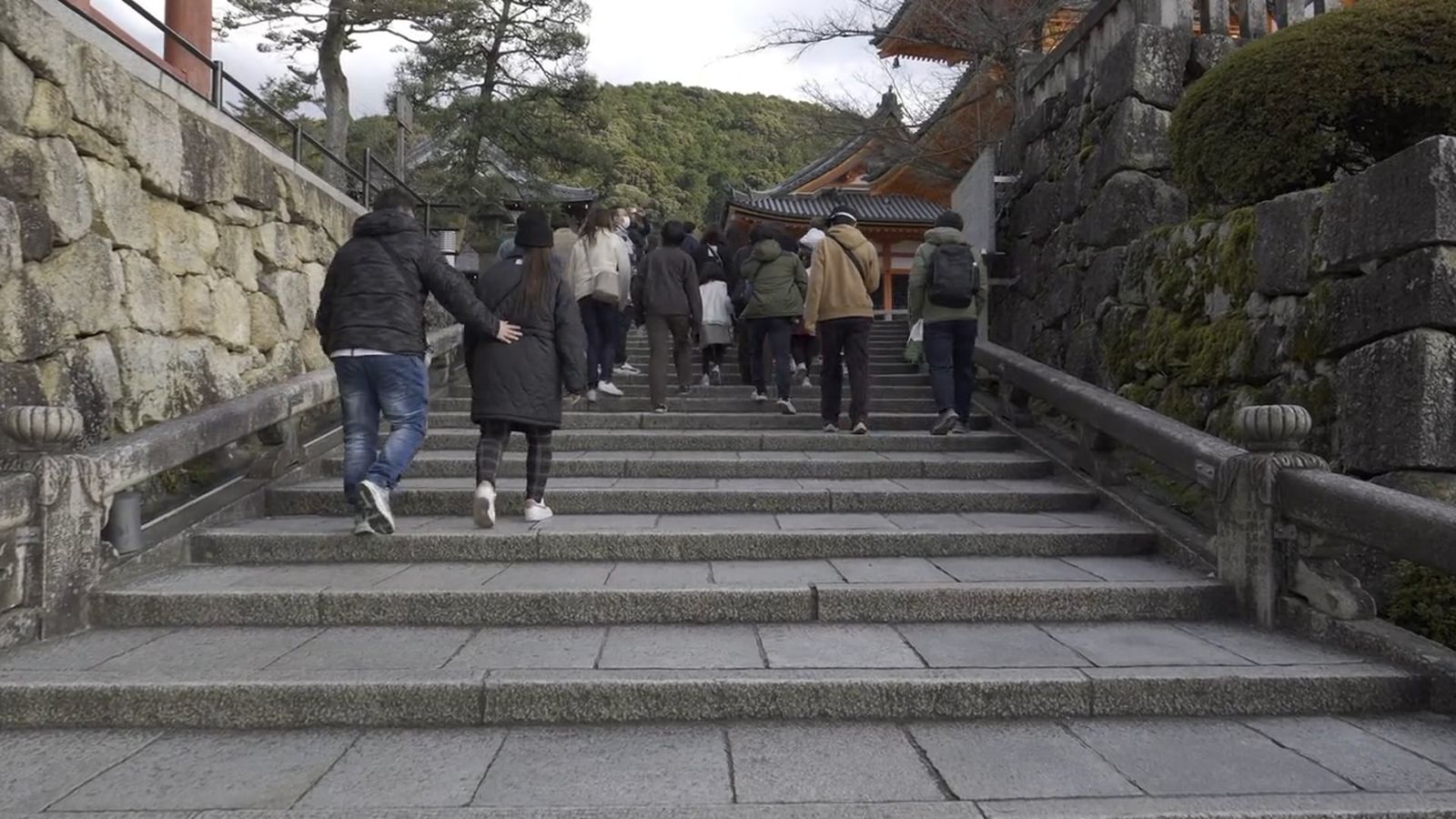 People walking through a tunnel of orange pillars Free Stock Video ...